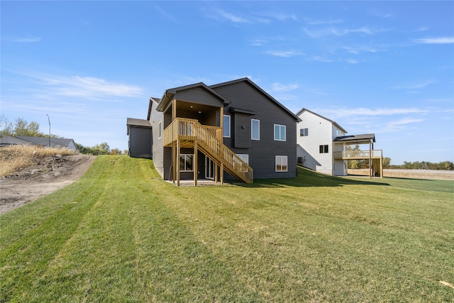 rear view of house featuring a lawn and a deck