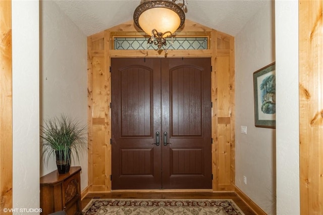 foyer entrance with a textured ceiling and vaulted ceiling