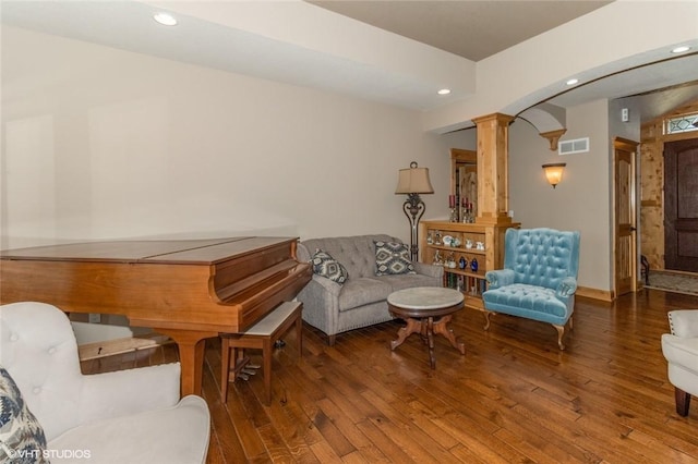 living area featuring hardwood / wood-style floors and ornate columns