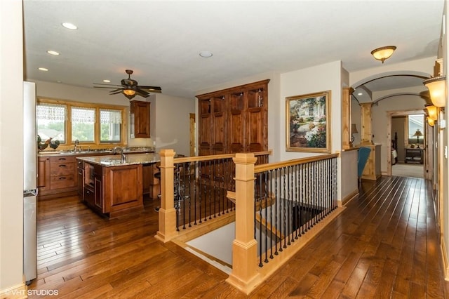 kitchen featuring stainless steel fridge, sink, a kitchen island, and dark hardwood / wood-style floors