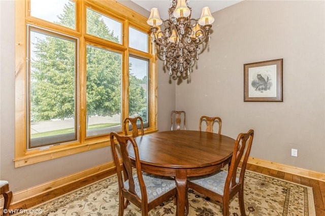 dining space with wood-type flooring and an inviting chandelier