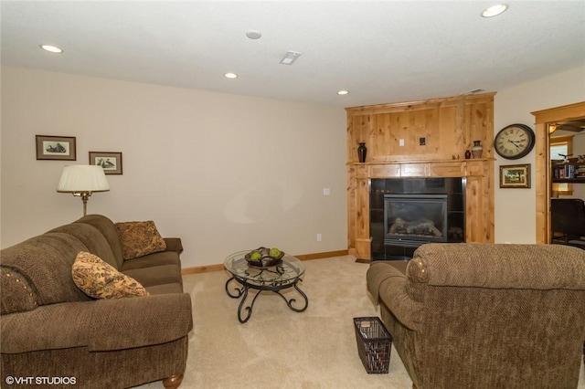 living room with light colored carpet and a tiled fireplace