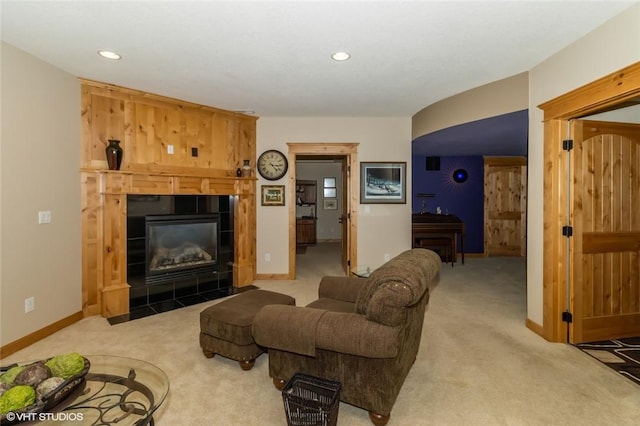 carpeted living room featuring a tiled fireplace