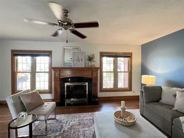 living room with a wealth of natural light, wood-type flooring, and ceiling fan