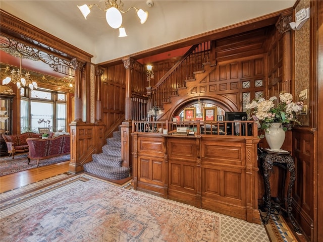 interior space with hardwood / wood-style flooring, wooden walls, and an inviting chandelier