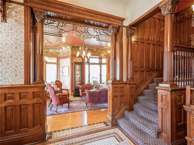 stairs with wood-type flooring and decorative columns