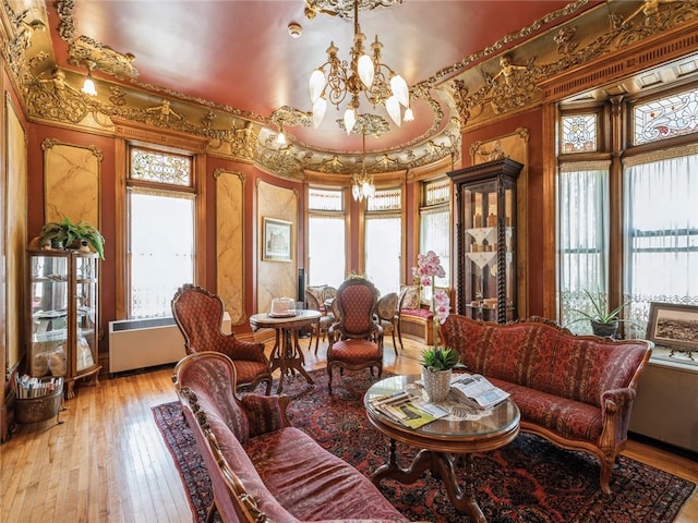 interior space featuring a notable chandelier, a raised ceiling, and light wood-type flooring