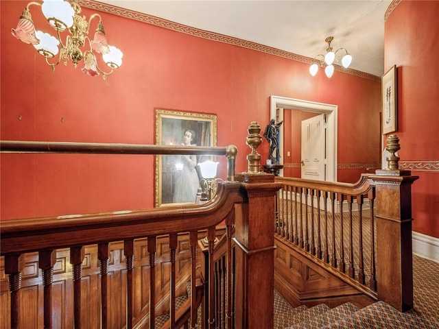 hall with carpet flooring and an inviting chandelier