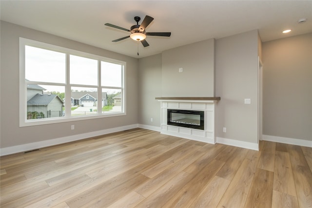 unfurnished living room featuring ceiling fan and light hardwood / wood-style flooring