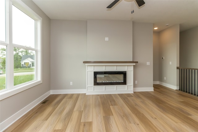 unfurnished living room with ceiling fan and light wood-type flooring