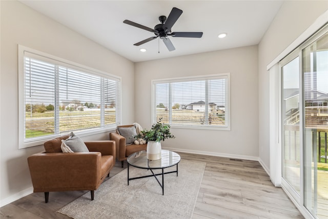 living area featuring ceiling fan and light wood-type flooring