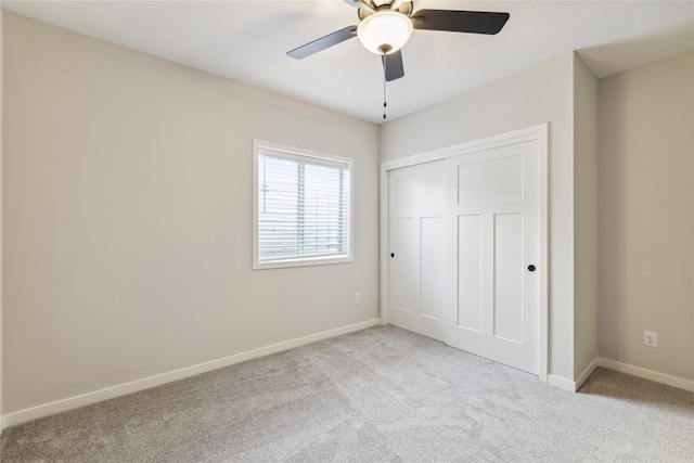 unfurnished bedroom with light carpet, a closet, and ceiling fan