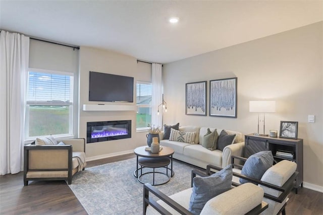 living room with dark hardwood / wood-style floors and a healthy amount of sunlight