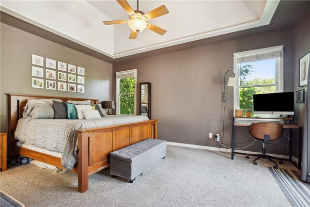 bedroom featuring ceiling fan, a raised ceiling, and carpet flooring