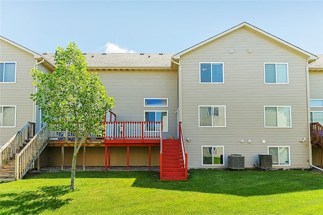 back of property with central AC unit, a lawn, and a deck