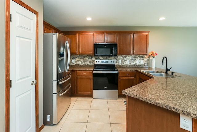 kitchen featuring appliances with stainless steel finishes, tasteful backsplash, sink, kitchen peninsula, and light tile patterned floors