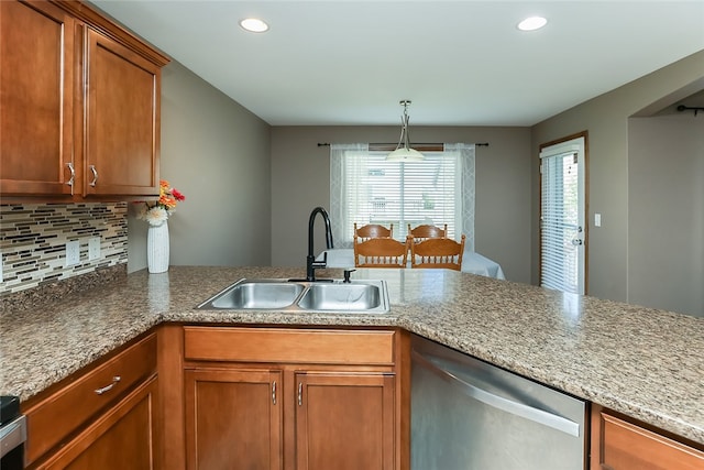 kitchen with tasteful backsplash, hanging light fixtures, sink, dishwasher, and light stone counters