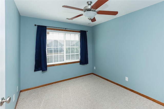 carpeted spare room featuring ceiling fan