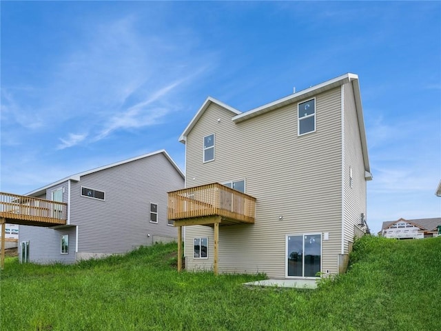 back of house with a wooden deck and a lawn