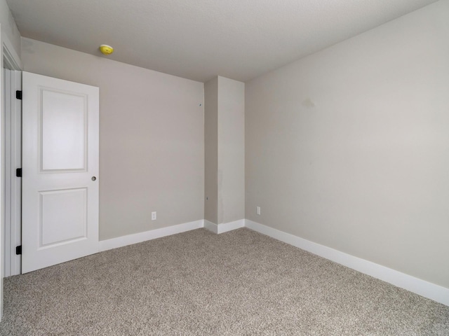 unfurnished room featuring carpet floors and baseboards