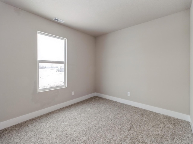empty room featuring visible vents, carpet, and baseboards
