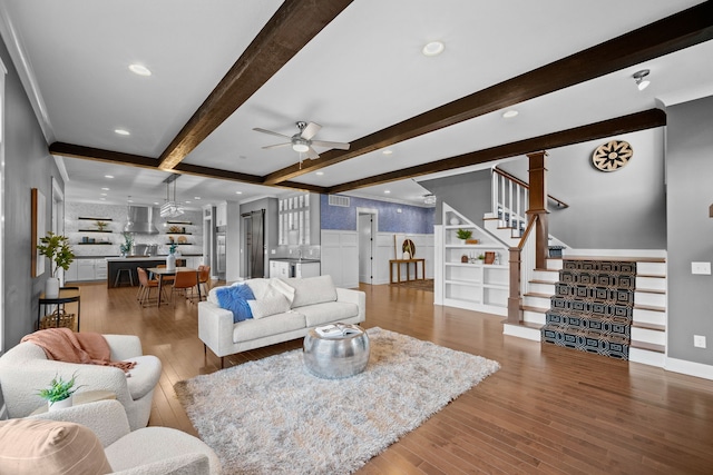 living room with ceiling fan, wood-type flooring, and beam ceiling