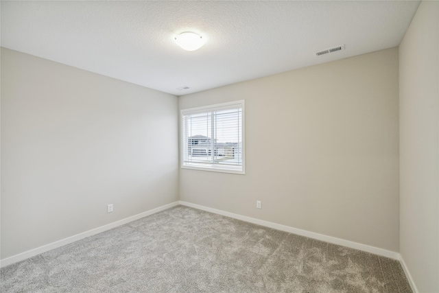 carpeted empty room with visible vents and baseboards