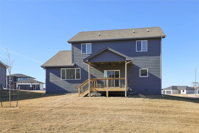 back of property with ceiling fan and a lawn