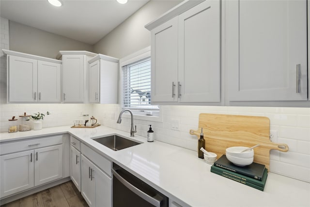 885 NW Frescott Cir, Waukee, IA 50263 - kitchen featuring stainless steel dishwasher, a sink, light countertops, decorative backsplash, and white cabinetry