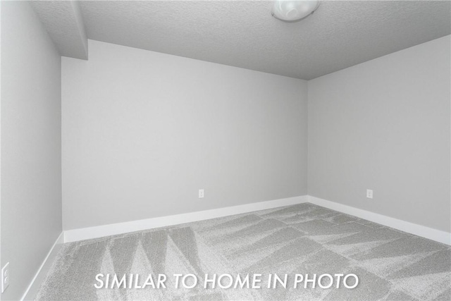 carpeted spare room with a textured ceiling