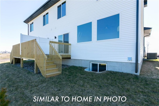 rear view of property featuring a yard, central air condition unit, and a wooden deck