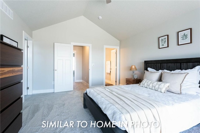 carpeted bedroom with lofted ceiling and ensuite bath