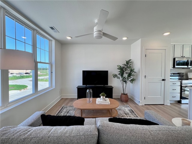 living room with ceiling fan and light hardwood / wood-style flooring