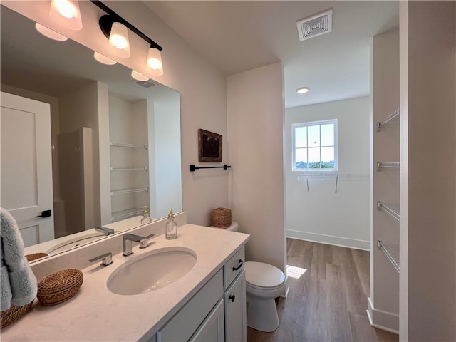 bathroom with wood-type flooring, vanity, and toilet