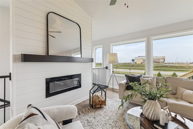 sunroom with ceiling fan, lofted ceiling, and a fireplace