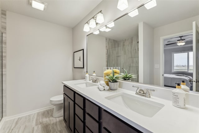 bathroom with ceiling fan, vanity, a shower with shower door, and toilet