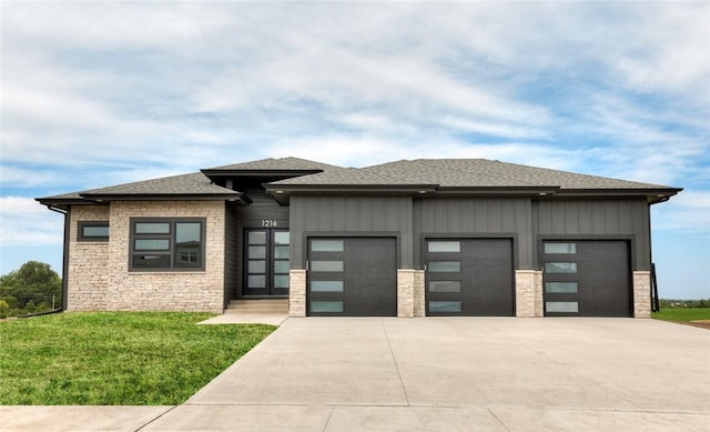 prairie-style home featuring a front yard and a garage