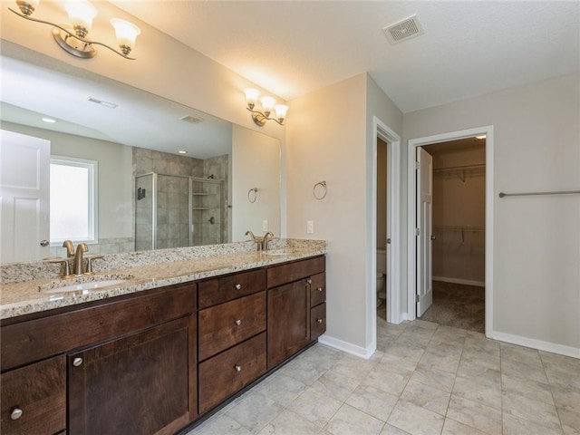 bathroom featuring vanity, toilet, and a shower with shower door