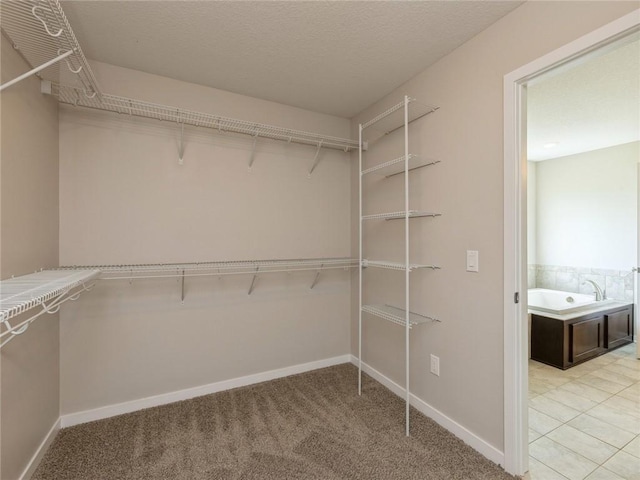 walk in closet with light tile patterned floors