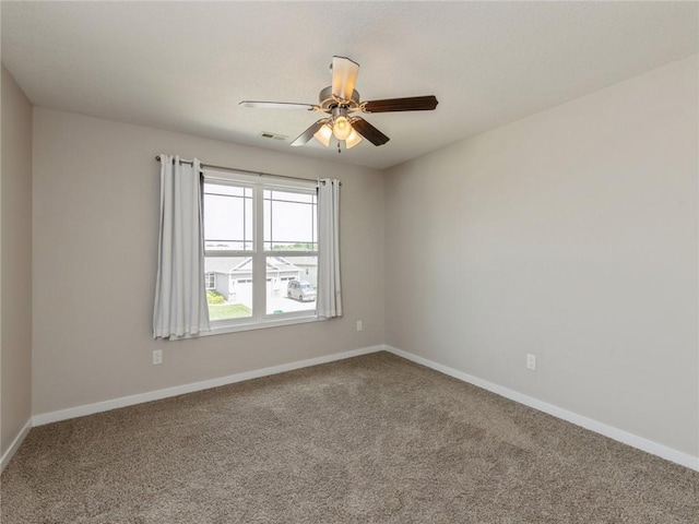 carpeted spare room with ceiling fan