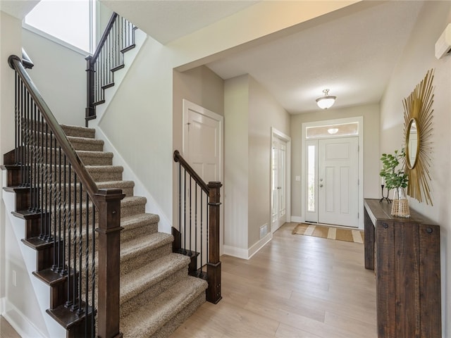 entryway with a textured ceiling and light hardwood / wood-style flooring