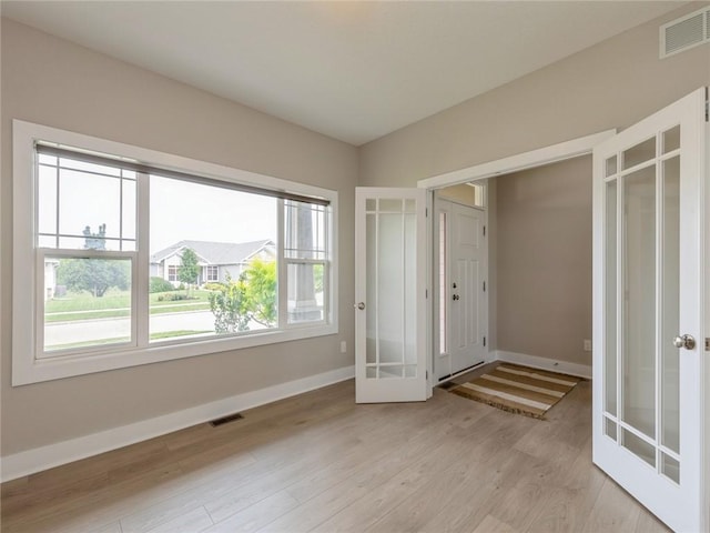 interior space with light hardwood / wood-style flooring and french doors