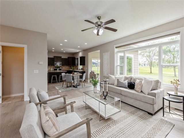 living room with ceiling fan and light wood-type flooring