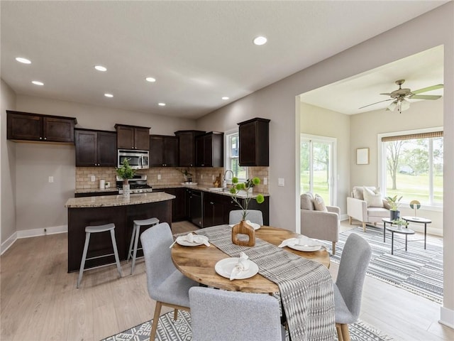 dining area with light hardwood / wood-style flooring, ceiling fan, and sink