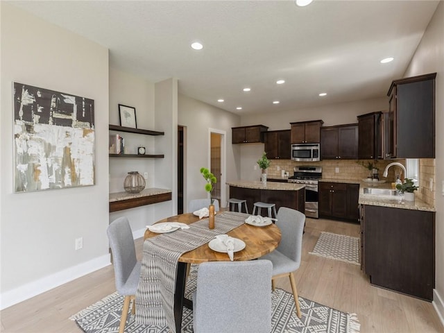 dining area featuring sink and light hardwood / wood-style flooring