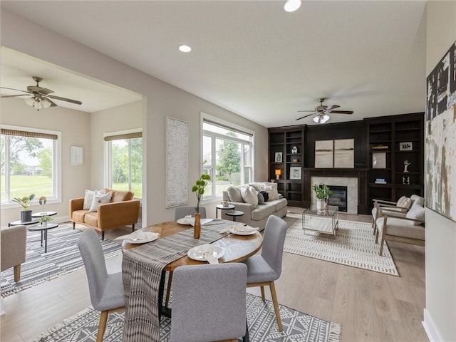 interior space with built in features, light hardwood / wood-style flooring, and ceiling fan