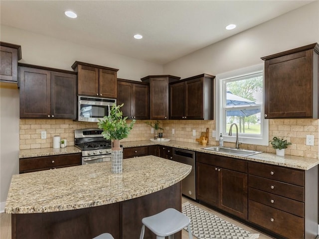 kitchen featuring backsplash, sink, stainless steel appliances, and dark brown cabinets