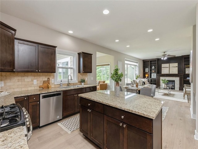 kitchen with light stone countertops, appliances with stainless steel finishes, a wealth of natural light, and sink