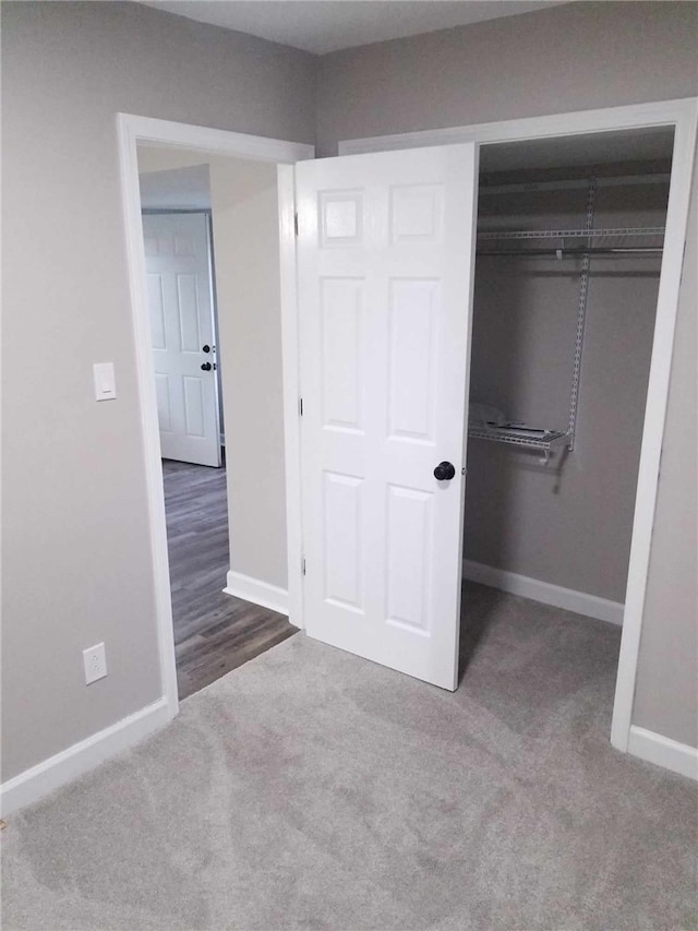 unfurnished bedroom with a closet and carpet floors