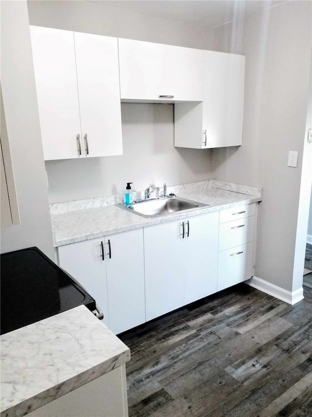 kitchen featuring dark hardwood / wood-style flooring, range with electric stovetop, white cabinets, and sink